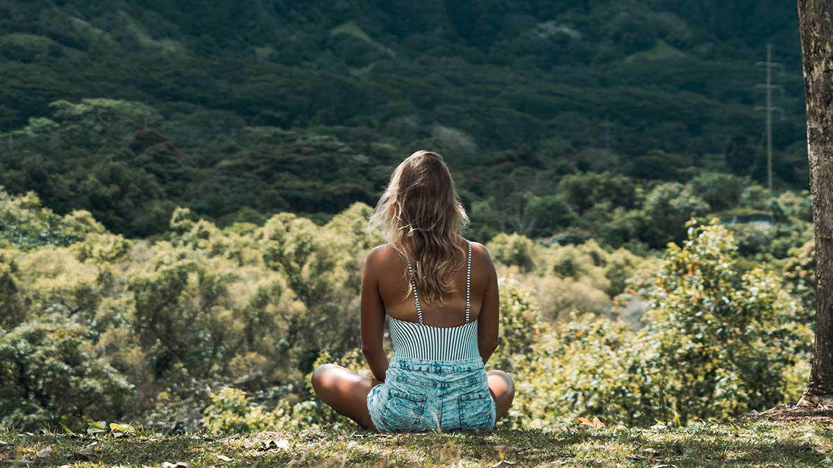 woman meditating in grass
