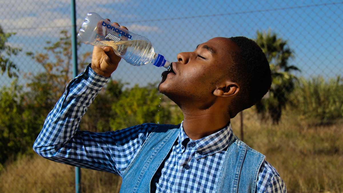 man drinking bottled water outside