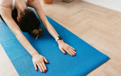 woman doing yoga child’s pose on yoga mat