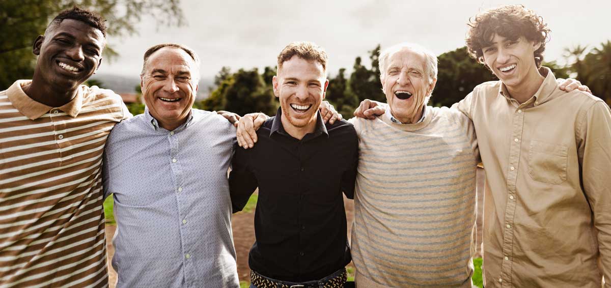 multigenerational group of men with different ethnicities having fun smiling in front of camera at park