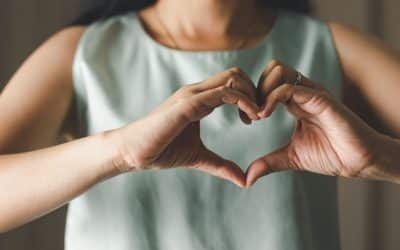 closeup of woman making heart shape with her hands